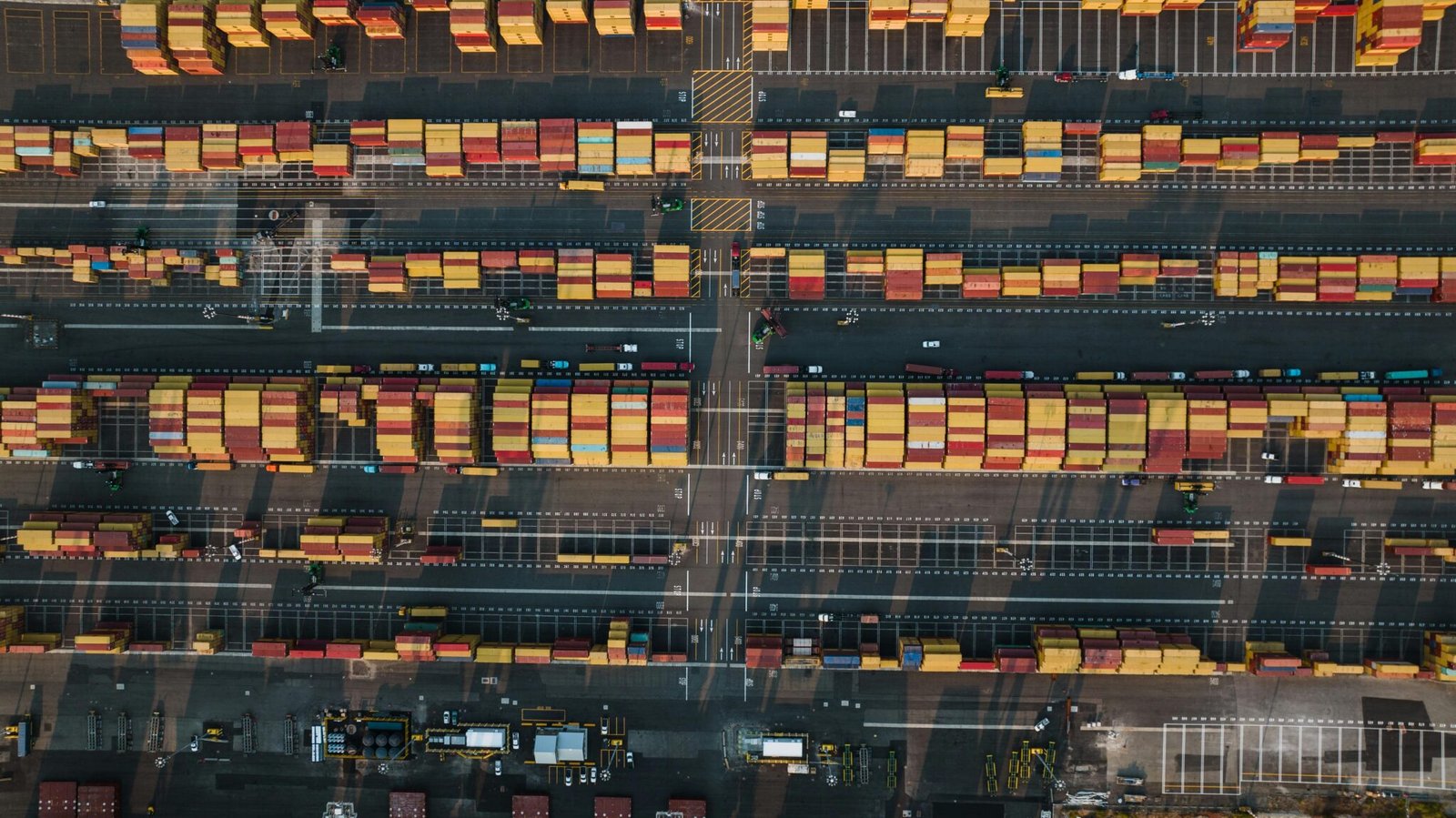 Drone shot of a bustling shipping container terminal in Seattle, showcasing vibrant industry activity.