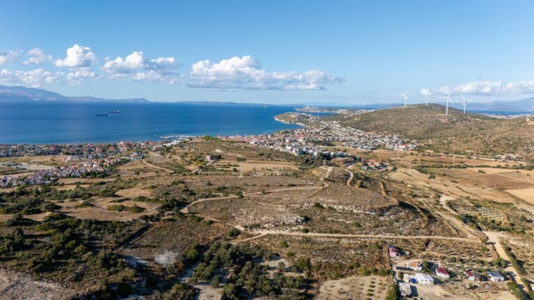 Aerial photograph of a coastal town with wind turbines and ocean view, showcasing summer landscape.
