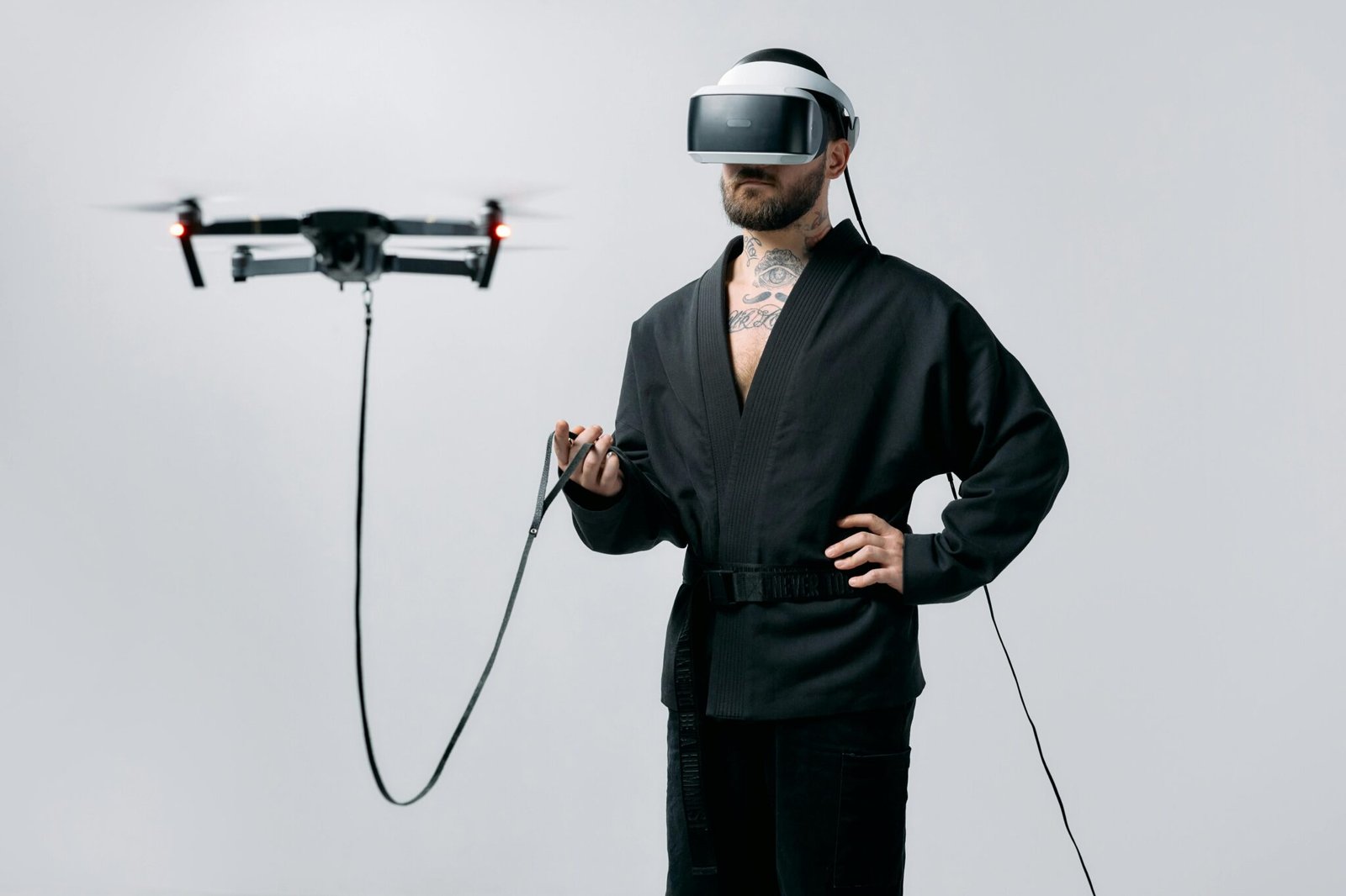 A man uses a VR headset to control a drone in a studio setting, highlighting innovation.