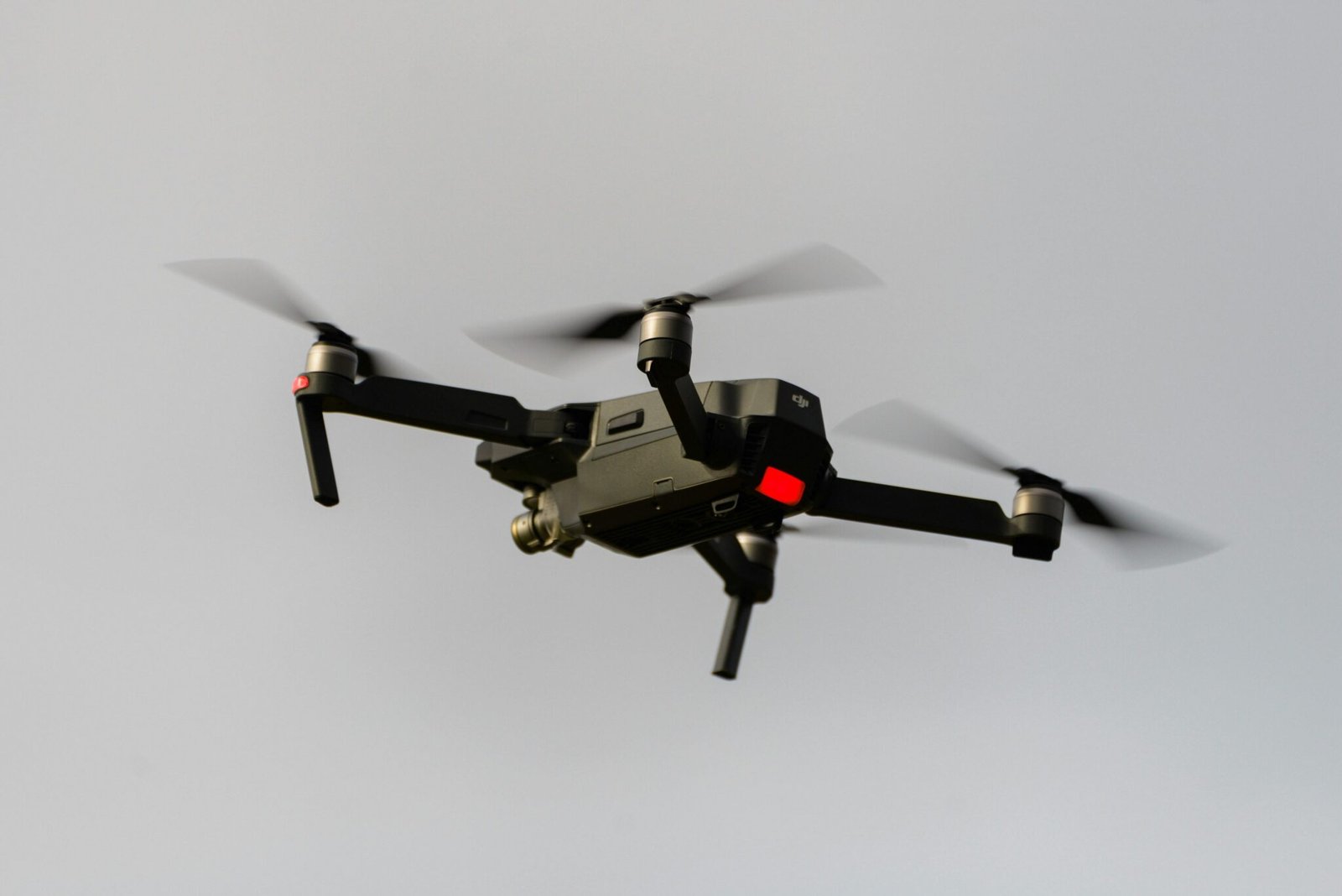 A sleek black quadcopter drone captured in mid-flight, demonstrating modern technology.