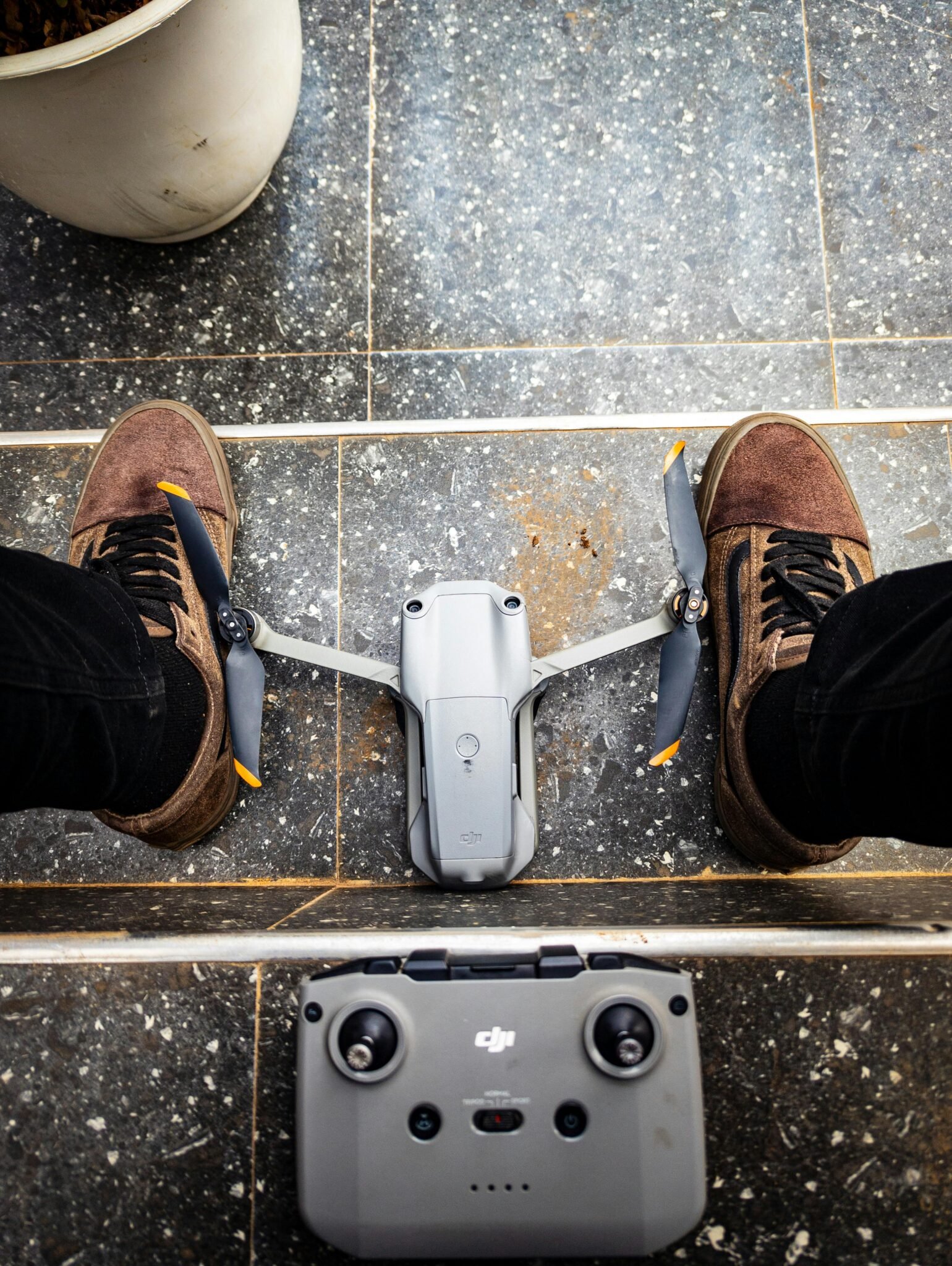 Person prepping drone on urban balcony. Ready for city flight.