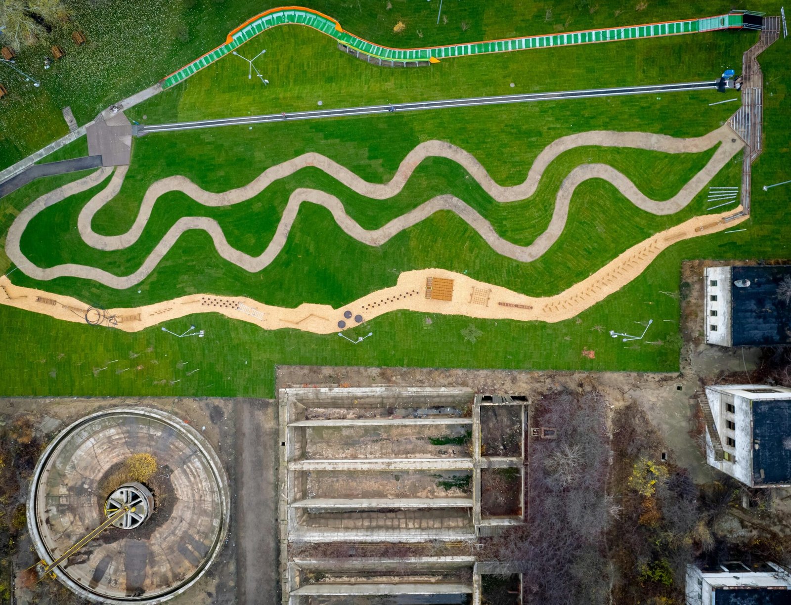 Aerial shot of a landscaped park alongside abandoned industrial structures in Romania.