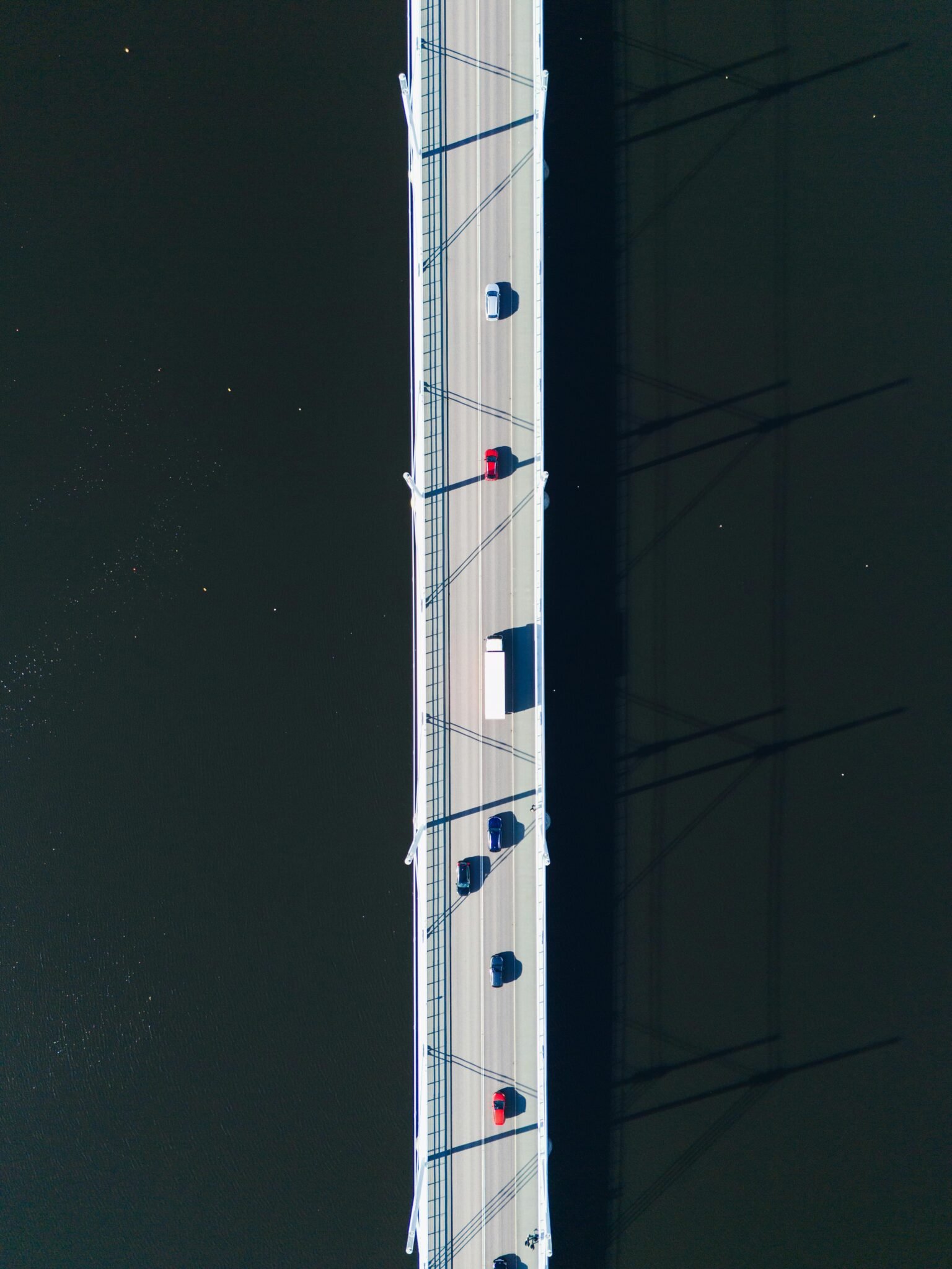 Top-down drone shot of a bridge over water in Jönköping, Sweden showing vehicles in transit.